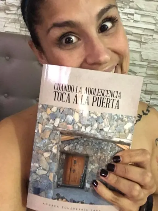 A woman holding the book Cuando la adolescencia toca la puerta